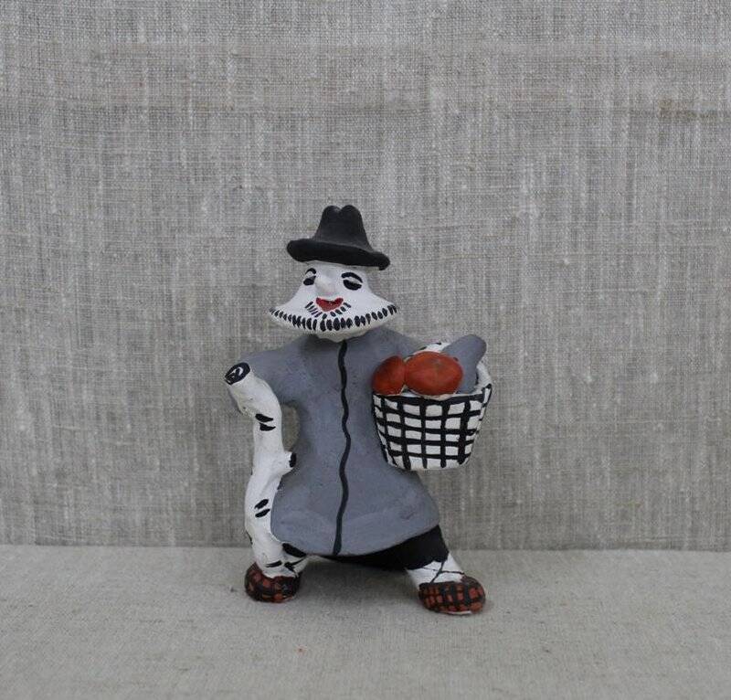 Каргопольская глиняная игрушка «Грибник» (Мужик с корзиной, наполненной грибами и с березовой тростью).