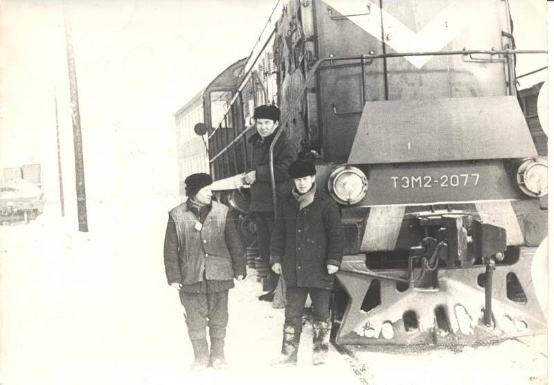 Фотография черно-белая. Иннокентий Васильевич Протасов и двое мужчин на подножке тепловоза