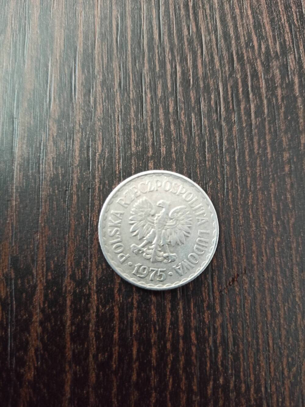 Нумизматика. Монета Польши достоинством  1 злотый 1975 года. Лицевая сторона – в центре «1 злотый» по кругу венок. Гербовая сторона – герб.