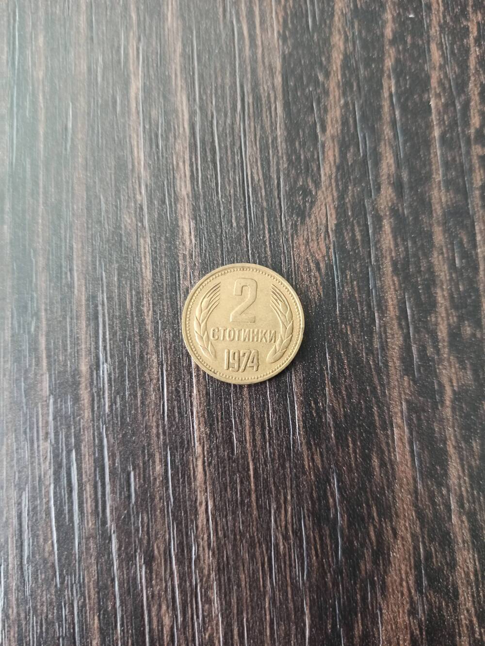 Нумизматика. Монета Болгарии достоинством 2 стотинки 1974 года. Лицевая сторона – в центре «2» Снизу 1974, по кругу – по одному колоску. Гербовая сторона – герб.