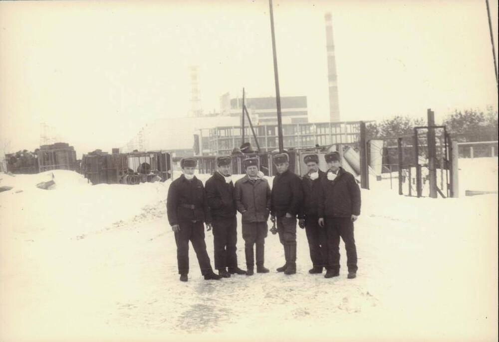 Фото групповое. Стоят мужчины на фоне энергоблока, первый слева Прахов Г. Д. – ликвидатор аварии на ЧАЭС. 1986 г.