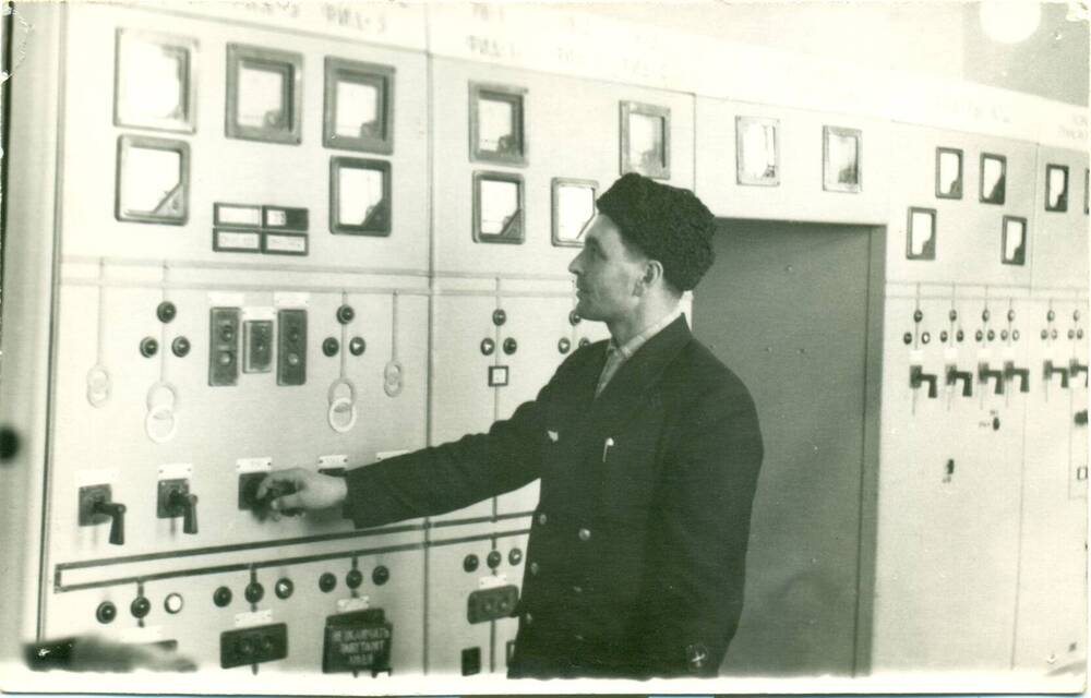Фотография чёрно-белая: Лысюк Алексей Яковлевич во время работы на ж/д подстанции.